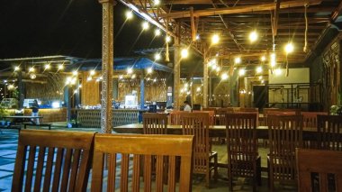 Geceleri bir kafedeki atmosfer, çok güzel, etrafında ışıklar var, çok romantik.