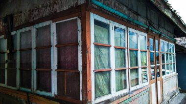 Basit bir Tengger kabile evinin köşesi tahtadan yapılmıştır ve neredeyse cam pencerelerle çevrilidir..