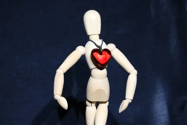 Beyaz gömlekli bir manken ve siyah arka planda kırmızı kalp..
