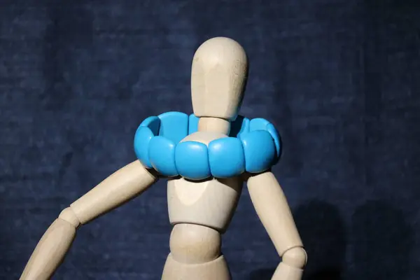 Siyah arka planda oyuncağı olan mavi kukla