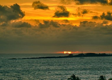 Bulutlu bir Bahamalar sabahında, Atlantik Okyanusu gün doğumunda sakindi, gökyüzündeki muhteşem renk dizisini yansıtıyordu.