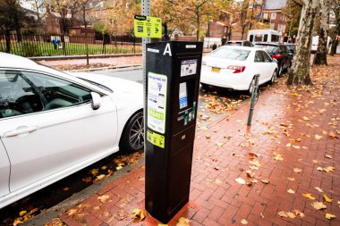 Philadelphia, Pensilvanya 'nın tarihi bölgesinde ücretli bir parkmetre. Kaldırımlar yağmurlu bir sonbahar gününde tuğladan yapılmıştır..