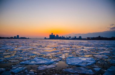 Detroit şehir merkezinin günbatımında Detroit nehrinin donmuş görüntüsü