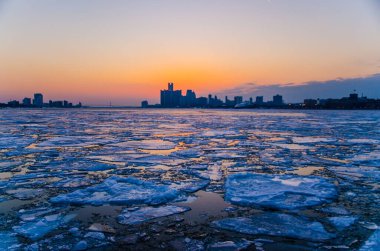 Detroit şehir merkezinin günbatımında Detroit nehrinin donmuş görüntüsü