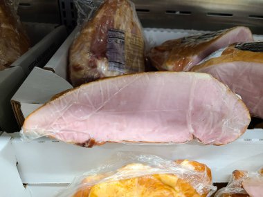 A case of ham for sale in a white box at a grocery store