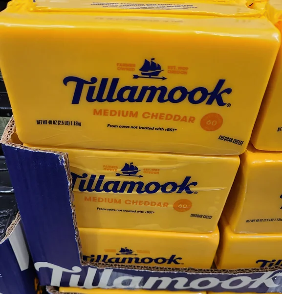 A block of Tillamook medium cheddar cheese in a cardboard box. The case is on a pallet.