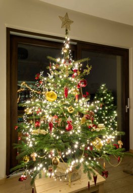 Oturma odasında Noel ağacı, süslemeler, balolar