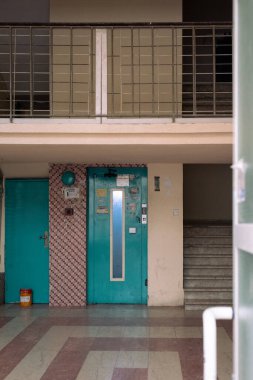 Eski bir binanın zemin katındaki eski yeşil asansör. Yangın, korkuluk gibi durumlarda kullanmayın.