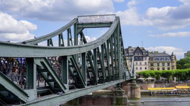 Famous Iron Bridge for pedestrians called Eiserner Steg in the city of Frankfurt - FRANKFURT MAIN, GERMANY - JULY 12, 2022 clipart