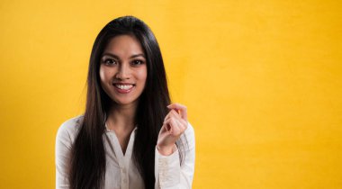 Tarafsız bir geçmişe karşı kendinden emin genç bir kadın. Stüdyo fotoğrafçılığı.