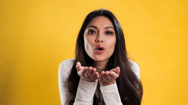 Genç ve güzel bir kadın kameraya bir öpücük yolluyor. Stüdyo fotoğrafçılığı.