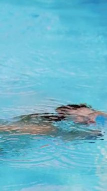 Sexy girl in bikini has fun in the swimming pool on a sunny day - Vertical video