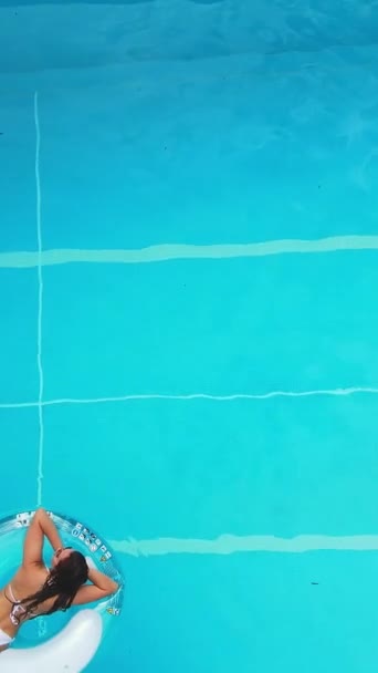 漂亮的姑娘躺在游泳池的气垫上 从上面看 垂直录像 — 图库视频影像