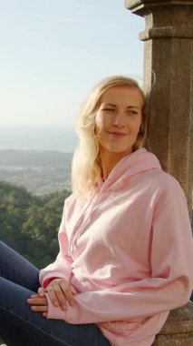 Portekiz 'de Pena Sarayı' nın duvarında oturan genç bir kadın. Seyahat fotoğrafçılığı.