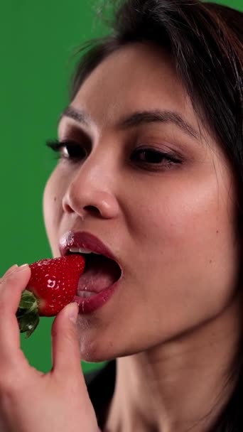若い女性がイチゴに噛み込む クローズアップ スタジオ撮影 — ストック動画