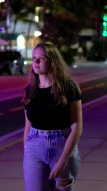 Gece Miami Plajı 'nda Renkli Okyanus Yolu. Sokakta yürüyen genç bir kadın. Seyahat fotoğrafçılığı.