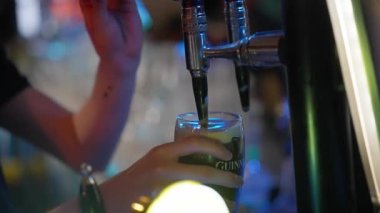 Draw a fresh Guinness beer in a pub - CITY OF DUBLIN, IRELAND - APRIL 20, 2022