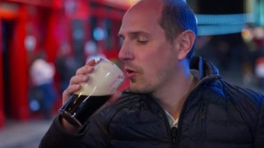 Geceleri Dublin 'in Temple Bar bölgesinde bira içen adamlar İrlanda' ya seyahat fotoğrafçılığı yapıyor.
