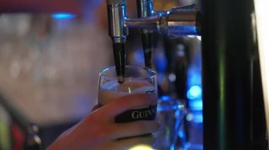Draw a fresh Guinness beer in a pub - CITY OF DUBLIN, IRELAND - APRIL 20, 2022