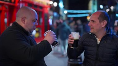 Geceleri Dublin 'in Temple Bar bölgesinde bira içen adamlar İrlanda' ya seyahat fotoğrafçılığı yapıyor.