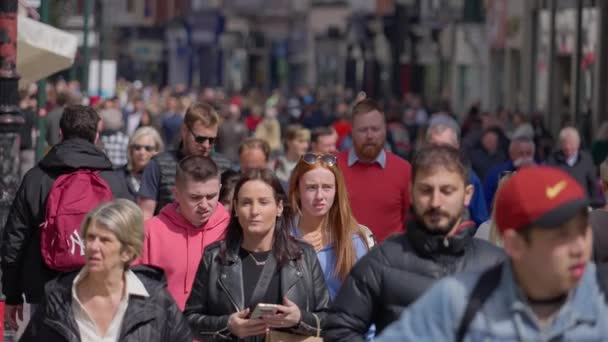 忙しい歩行者ゾーンを歩く大勢の人々 スローモーションでグラフトン通りダブリン アイルランドのダブリン市 エイプリル20 2022 — ストック動画