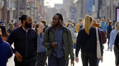 Crowd of people walking through a busy pedestrian zone - Grafton Street Dublin in slow motion - CITY OF DUBLIN, IRELAND - APRIL 20, 2022
