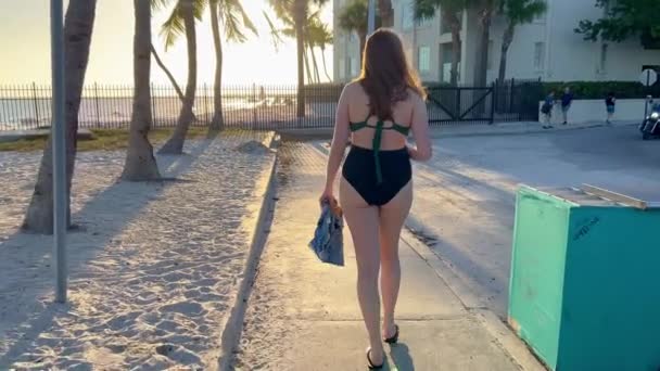 若い女性はそこで日光浴後ヒッグスビーチを残します Key West フロリダ 2022年2月20日 — ストック動画