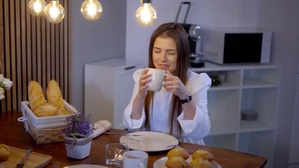 年轻美丽的女人在早餐桌上喝一杯咖啡 货架摄影 — 图库视频影像