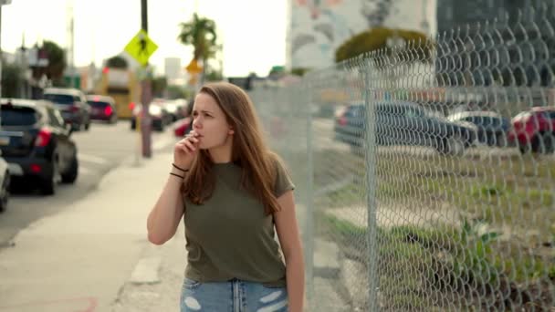 若い女性は極端なスローモーションでタバコを吸う考えで失わ マイアミフロリダ州旅行写真 — ストック動画