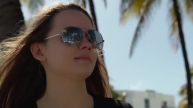 Young pretty woman enjoys the sun of Miami Beach - extreme slow-motion video