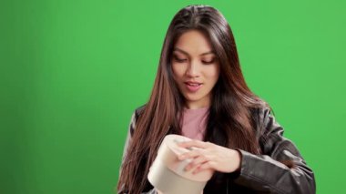 Stüdyoda kendine güveni olan Asyalı bir kız hediye kutusunu açıyor - aşırı yavaş çekim