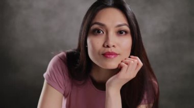 Young Asian woman in a studio doing some gestures for a photo shooting - extreme slow motion