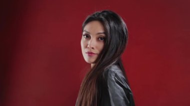 Young Asian woman in a leather jacket poses for the camera - extreme slow motion