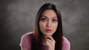 Young Asian woman in a studio doing some gestures for a photo shooting - extreme slow motion