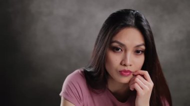 Young Asian woman in a studio doing some gestures for a photo shooting - extreme slow motion