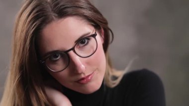 Stüdyoda kameraya poz veren güzel yüzlü sarışın bir kızın son derece yavaş çekim görüntüsü.