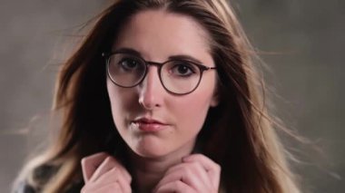 Stüdyoda kameraya poz veren güzel yüzlü sarışın bir kızın son derece yavaş çekim görüntüsü.