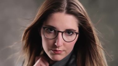 Stüdyoda kameraya poz veren güzel yüzlü sarışın bir kızın son derece yavaş çekim görüntüsü.