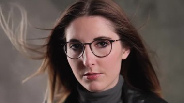 Stüdyoda kameraya poz veren güzel yüzlü sarışın bir kızın son derece yavaş çekim görüntüsü.