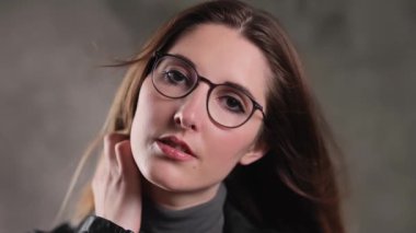 Stüdyoda kameraya poz veren güzel yüzlü sarışın bir kızın son derece yavaş çekim görüntüsü.