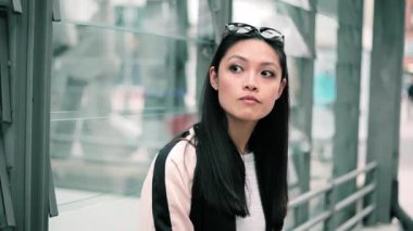 Güzel Asyalı kadın sokakta birini bekliyor. Fotoğrafçılık.