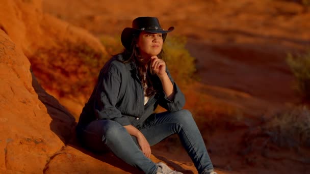 アリゾナの砂漠で赤い岩でリラックスするカウガール 旅行写真 — ストック動画