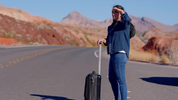 年轻女子独自一人带着行李箱在沙漠中行走 旅行摄影 — 图库视频影像