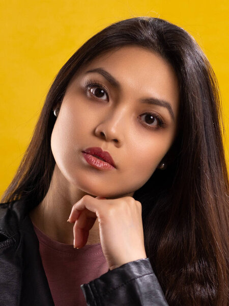 Young Asian woman with a beautiful face - portrait shot against color background. High quality photo