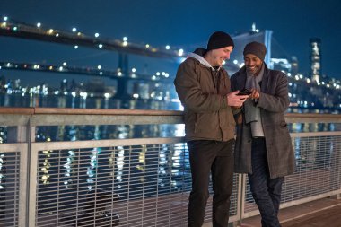 Geceleri Brooklyn Köprüsü 'nde iki adam. Sokak fotoğrafçılığı.