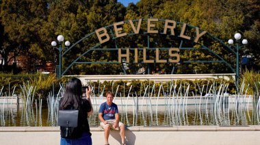 Santa Monica Bulvarı, LOS ANGELES, ABD 'deki Beverly Hills tabelasında fotoğraf çeken turistler. 2023