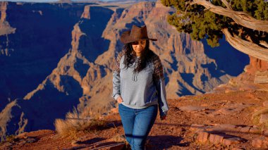 Muhteşem Büyük Kanyon 'un inanılmaz manzarasının tadını çıkaran genç bir kadın. Seyahat fotoğrafçılığı.