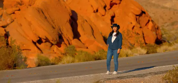 Nuori Nainen Yllään Cowboy Hattu Kävely Yksinäinen Tie Autiomaassa Arizona — kuvapankkivalokuva