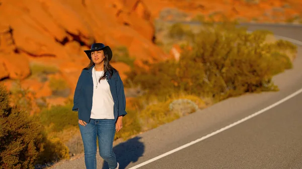 Nuori Nainen Yllään Cowboy Hattu Kävely Yksinäinen Tie Autiomaassa Arizona — kuvapankkivalokuva