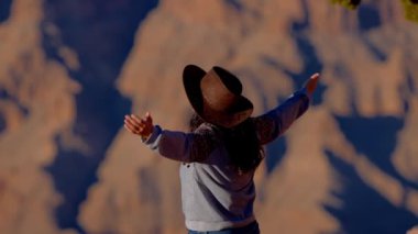Genç kadın, Büyük Kanyon 'un nefes kesici manzarasına hayran kalıyor. Seyahat fotoğrafçılığı.